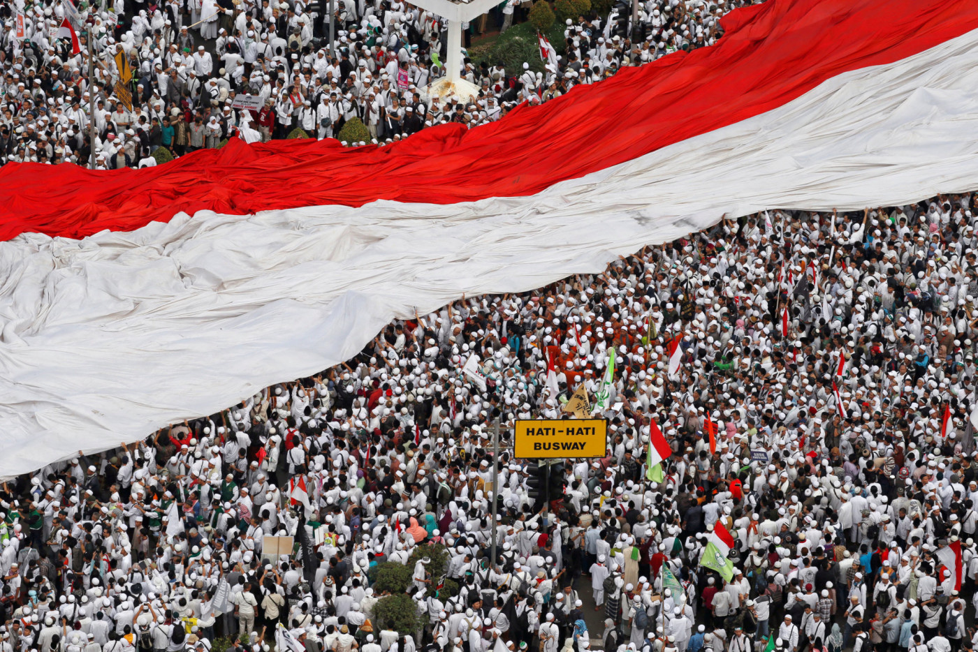 FILE PHOTO - Members of hardline Muslim groups hold a big national flag as they attend a protest against Jakarta's incumbent governor Basuki Tjahaja Purnama, an ethnic Chinese Christian running in the upcoming election, in Jakarta, Indonesia, November 4, 2016. REUTERS/Beawiharta/File Photo